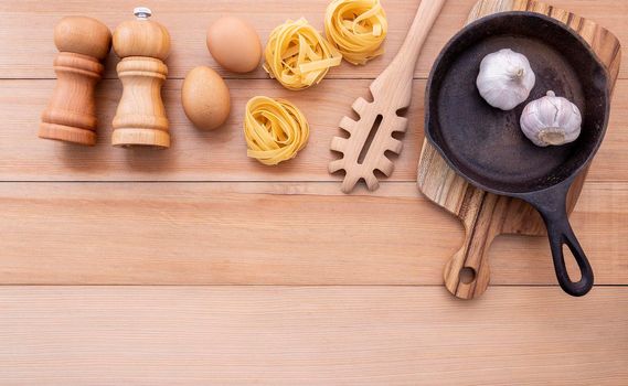 Italian foods concept and menu design . Empty cast iron skillet and  pasta ladle on wooden background.