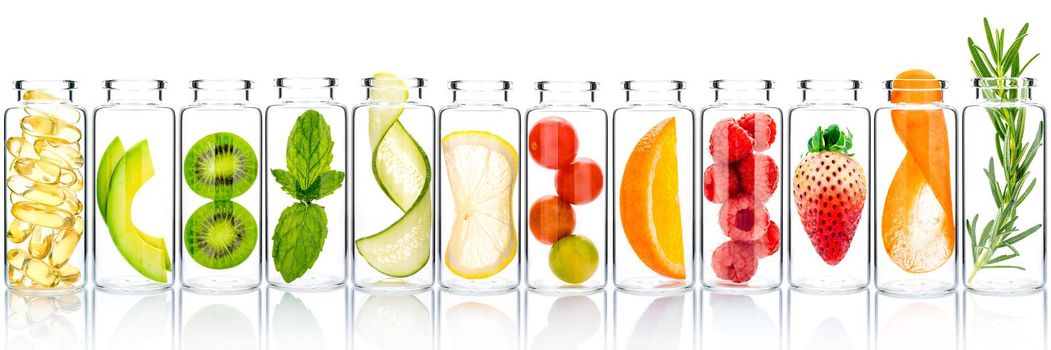 Homemade skin care with fruits ingredients avocado ,orange ,blueberry ,pomegranate ,kiwi ,lemon slice ,cucumber ,tamarind ,strawberry and raspberry in glass bottles isolated on white background.