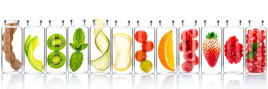 Homemade skin care with fruits ingredients avocado ,orange ,blueberry ,pomegranate ,kiwi ,lemon slice ,cucumber ,tamarind ,strawberry and raspberry in glass bottles isolated on white background.