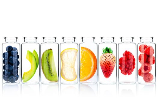 Homemade skin care with fruits ingredients avocado ,orange ,blueberry ,pomegranate ,strawberry and raspberry in glass bottles isolate on white background.