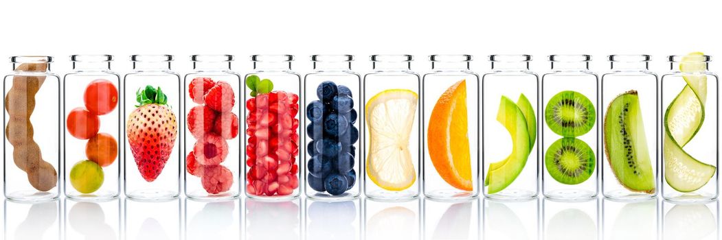 Homemade skin care with fruits ingredients avocado ,orange ,blueberry ,pomegranate ,kiwi ,lemon slice ,strawberry and raspberry in glass bottles isolated on white background.