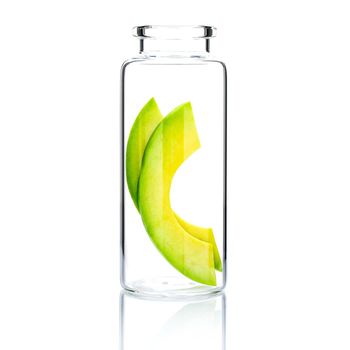 Homemade skin care with  avocado slice in a glass bottle isolated on white background.