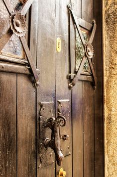 Old wooden door in Obidos Lisbon. Wrought metal details on the door.