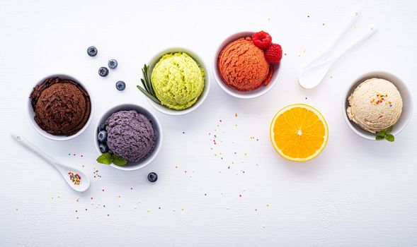 Various of ice cream flavor ball blueberry ,lime ,pistachio ,almond ,orange ,chocolate and vanilla set up on white wooden background . Summer and Sweet menu concept.