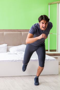 Young handsome man doing morning exercises in the hotel room