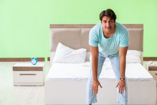 Young man in pajamas doing morning exercises 