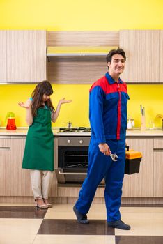 Woman with contractor at kitchen discussing repair