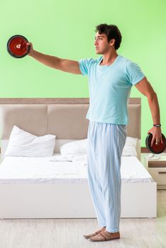 Young man in pajamas doing morning exercises 