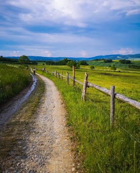 Long mountain trail with beautiful landscape in Rudawy Janowickie next to wooden railings 