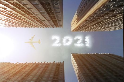 Airplane fly to make a cloud text 2021 in the sky with the city