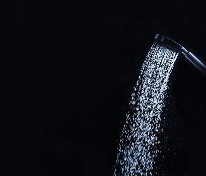 running water of shower faucet on dark background