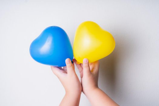 Heart-shaped balloons represent the sign of Down syndrome children. Balloons on hand