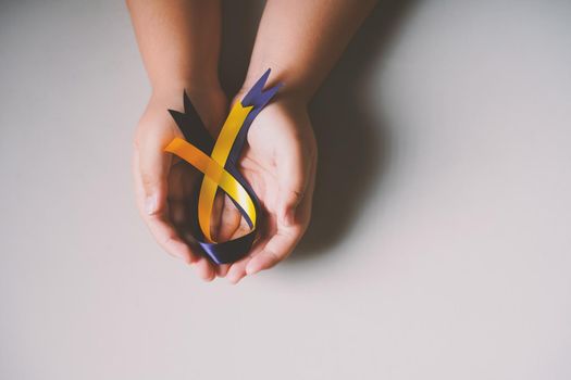 World down syndrome day with blue yellow ribbon bow color on hand