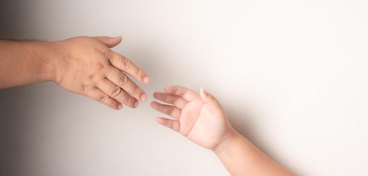 Father's hand to hold the hand of a child with Down's syndrome