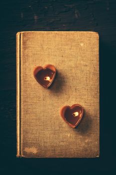 Couple heart is candles on old book, Vintage dark filter