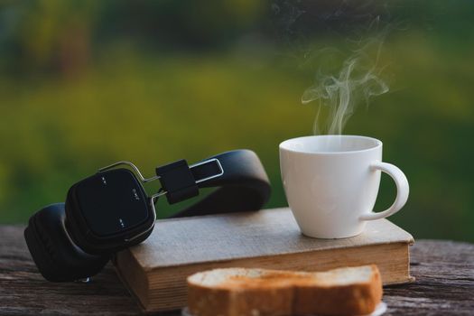 Coffee cup with bread on green blurred background