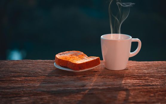 Coffee cup with bread on wooden table