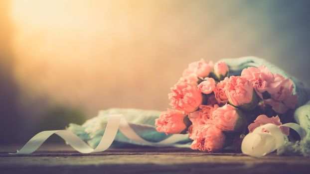 Still life with sweet carnation flowers on wooden table, Mothers day concept