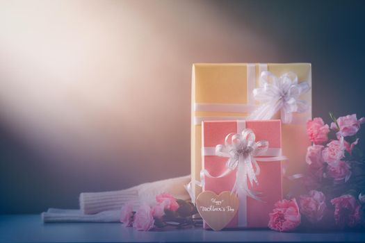 Still life with sweet carnation flowers and gift on table, Mothers day concept