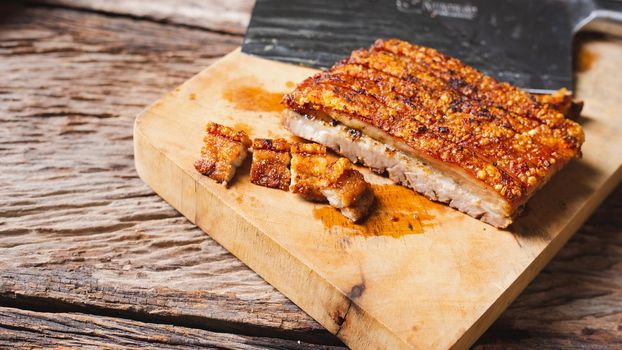 Roast Pork Belly on wooden chopping board with knife