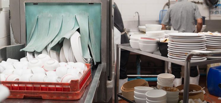 Man washing dish in sink at restaurant.People are washing the dishes too Cleaning solution