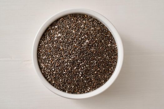 Chia seeds in a white bowl, top view