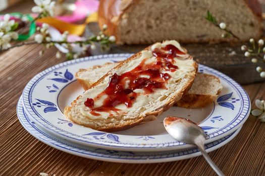 A slice of mazanec, traditional Czech sweet Easter pastry, similar to hot cross bun, with butter and marmalade