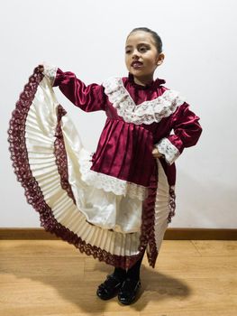 Little smiling girl with typical Peruvian Marinera costume