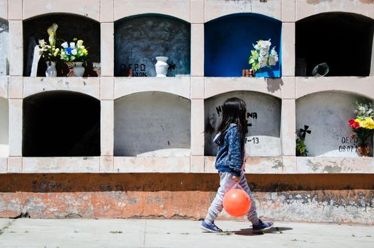 Girl on her back looking at the grave of a loved one in the cemetery of Canta - Lima - Peru