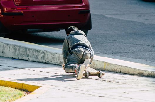 Child playing on the street with an artisan skateboard on a sunny day