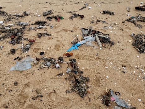 Sandy beach after a storm with garbage piles.