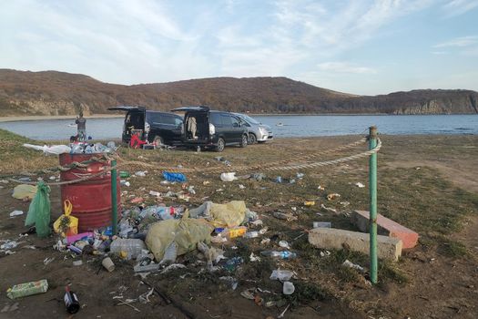 Vladivostok, Russia-October 16, 2019: People relax in the sea bay against the background of garbage.