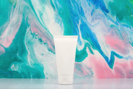 White cream tube on white table against marbled background with copy space. Concept of beauty products for skin care. Hydrating, moisturizing or exfoliating skin product
