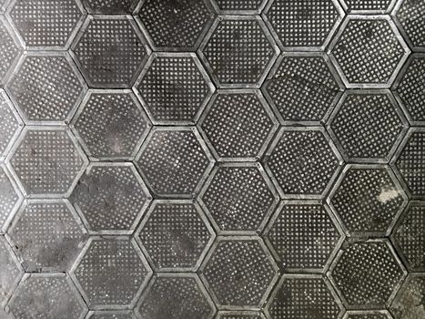texture of factory floor made of hexagonal cast iron tiles. Dirty, dark and old style.