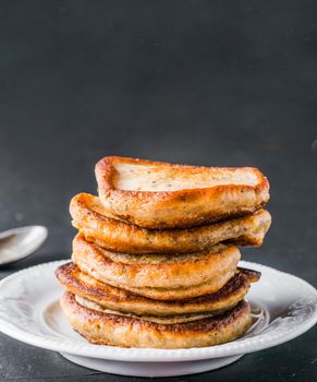 Stack of small pancakes with banana and chia seeds on black background. Pancake with chia or poppy seeds, without eggs. Eggless concept. Copy space