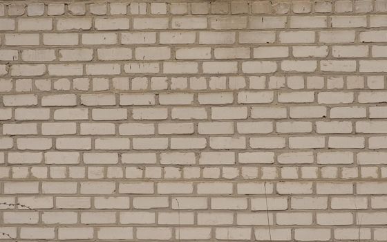 A white horizontal brick textured wall, yellowed with age. High quality photo