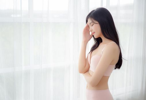 Beautiful portrait young asian woman sexy thinking idea weight loss near the windows for healthy, body of asia girl happy with diet and cheerful with wellbeing, lifestyle and relax concept.