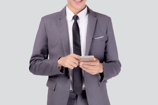 Portrait young asian business man in suit standing using smartphone to internet isolated on white background, businessman confident touch screen mobile phone with success, communication concept.