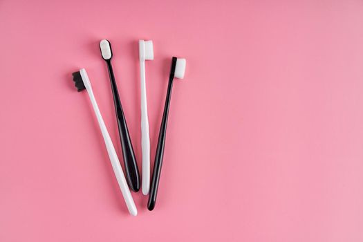 Fashionable toothbrush with soft bristles. Popular toothbrushes. Hygiene trends. Kit of toothbrushes on pink background.