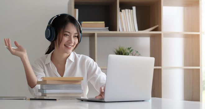 Side view head shot smiling mixed race lady wearing headset, communicating with client via video computer call.
