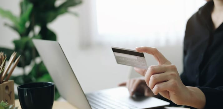 Hands holding credit card and using laptop. Online shopping

