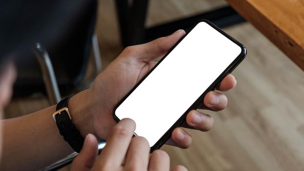 Cropped shot view of man hands holding smart phone with blank copy space screen for your text message or information content, female reading text message on cell telephone during in urban setting.
