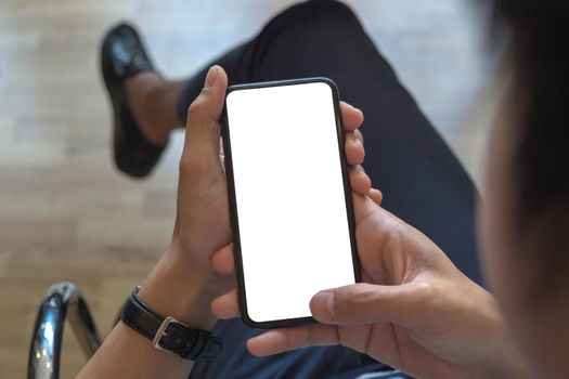 Cropped shot view of man hands holding smart phone with blank copy space screen for your text message or information content, female reading text message on cell telephone during in urban setting.

