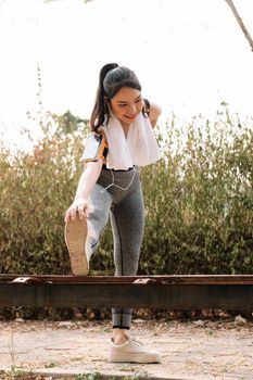 fitness, sport, exercising and lifestyle concept - woman stretching leg on stands