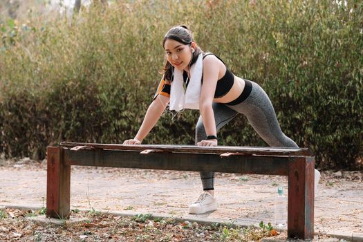 fitness, sport, exercising and lifestyle concept - woman stretching leg on stands