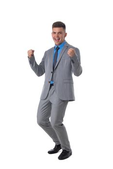 Young business man winner holding fists isolated on white background full length studio portrait