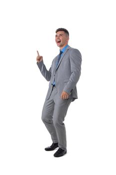 Full length portrait of a young business man in gray suit pointing at copy space isolated on white background