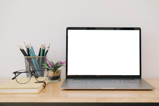 Blank screen Laptop computer and poster workspace background in modern office
