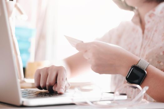 Online payment,woman's hands holding smartphone and using credit card for online shopping.