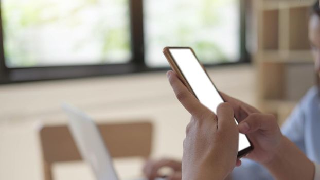 hand woman using a telephone, empty screen smart phone and computer on wooden table top view.